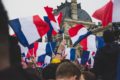 Un rassemblament avec des drapeaux français devant le Louvre à Paris (France).